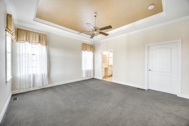 carpeted empty room featuring ceiling fan, crown molding, and a raised ceiling