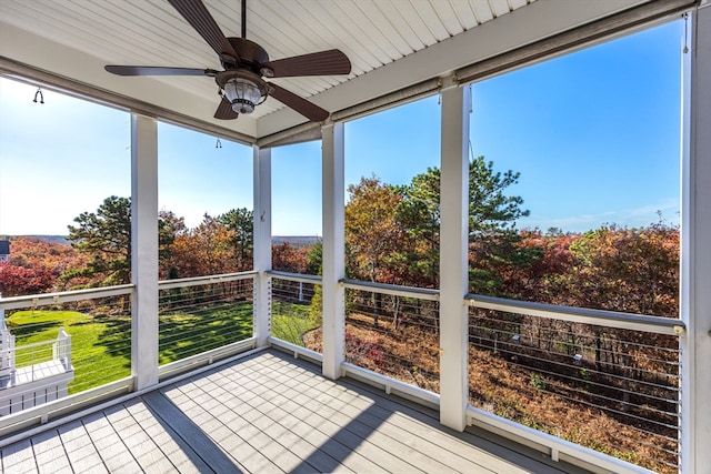 unfurnished sunroom featuring ceiling fan