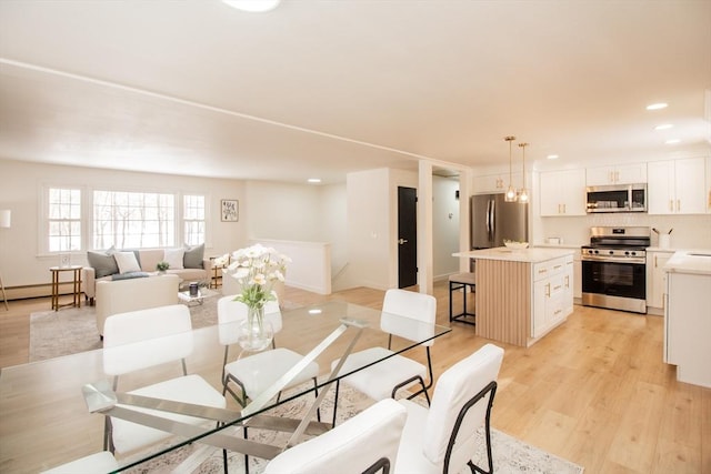 dining room with an inviting chandelier, light hardwood / wood-style floors, and baseboard heating