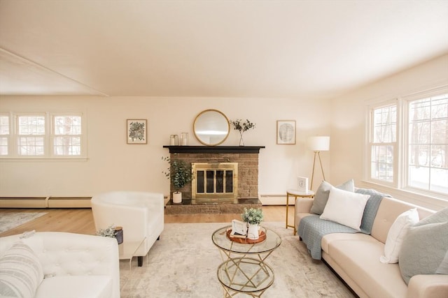 living room featuring a baseboard heating unit, a stone fireplace, and hardwood / wood-style floors