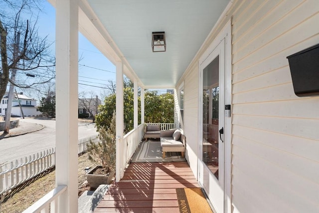 deck featuring a porch and fence