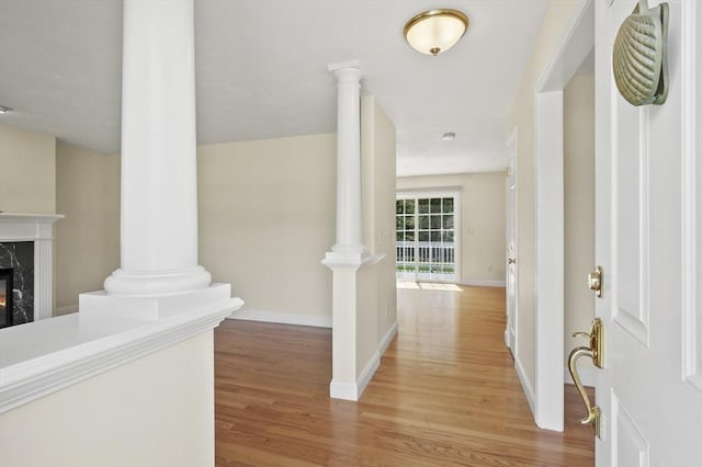 foyer featuring baseboards, a fireplace, and wood finished floors
