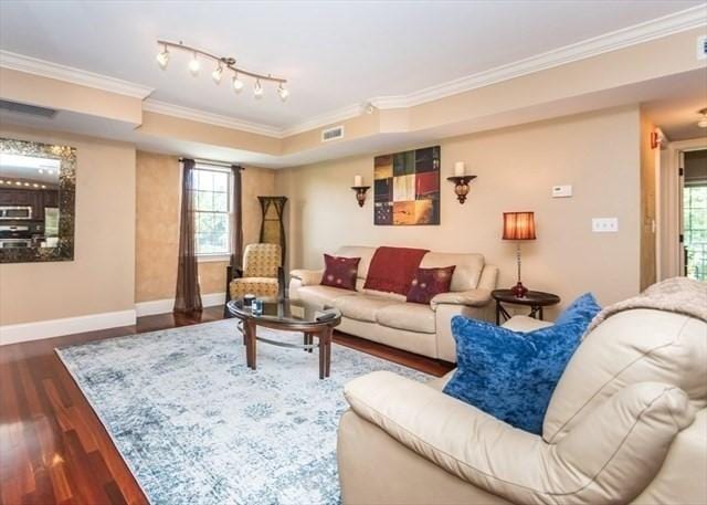 255 Winter St Unit 305, Waltham, MA 02451 - living area with crown molding, wood finished floors, and plenty of natural light