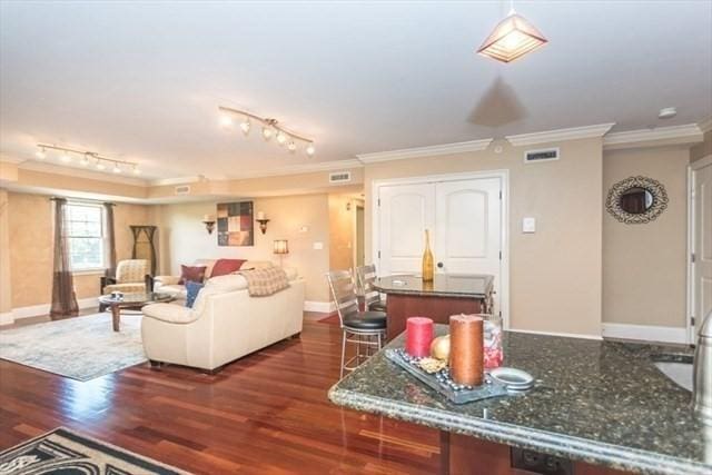 255 Winter St Unit 305, Waltham, MA 02451 - living room with dark wood finished floors, crown molding, and rail lighting