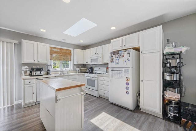 1249-1251 Rockdale Ave, New Bedford, MA 02740 - kitchen featuring white appliances, a skylight, a sink, wood finished floors, and recessed lighting