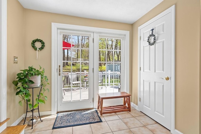 entryway with baseboards and light tile patterned flooring
