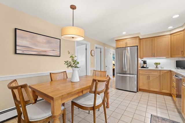 kitchen with appliances with stainless steel finishes, light countertops, decorative light fixtures, decorative backsplash, and light tile patterned floors