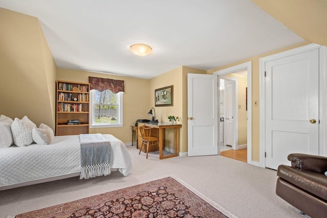 bedroom with light colored carpet and baseboards