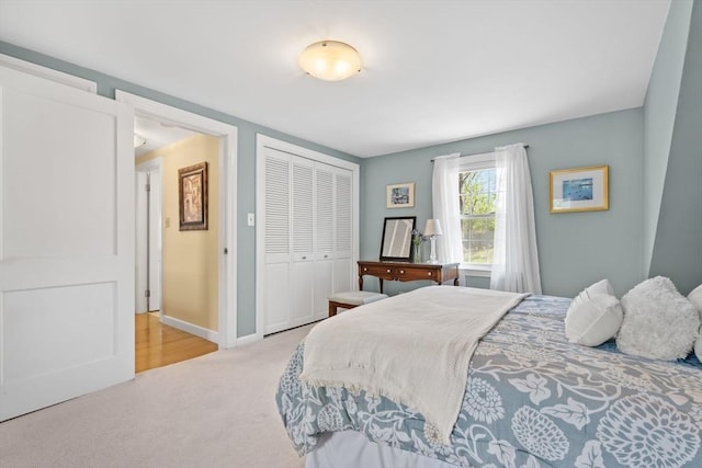 carpeted bedroom with baseboards and a closet