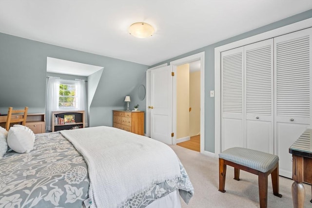 bedroom with a closet, baseboards, and light carpet