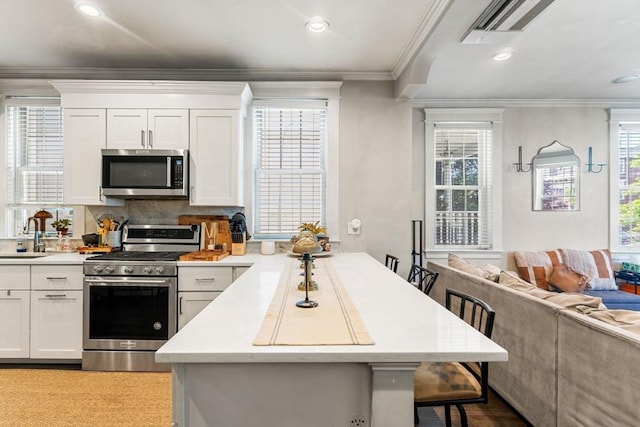 23 Dix St Unit 1, Boston, MA 02122 - kitchen with appliances with stainless steel finishes, a breakfast bar, a peninsula, a sink, and light countertops