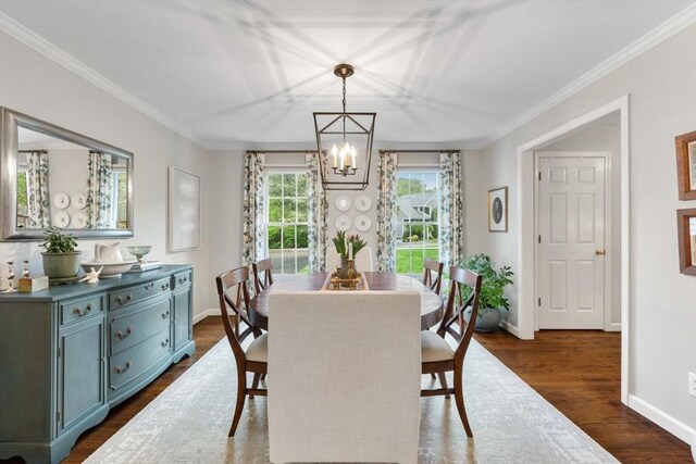 dining room featuring a chandelier, baseboards, crown molding, and dark wood finished floors