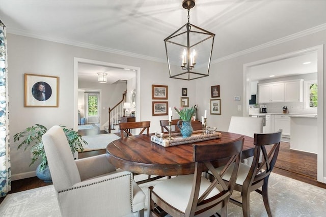 dining space with stairway, light wood-style flooring, a chandelier, ornamental molding, and baseboards