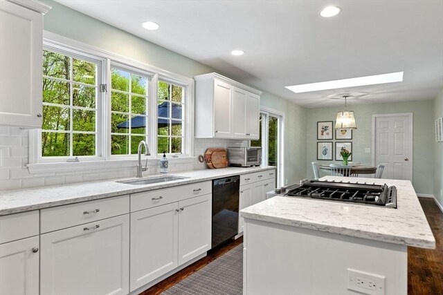 kitchen with a sink, dishwasher, stainless steel gas cooktop, a center island, and dark wood-style floors