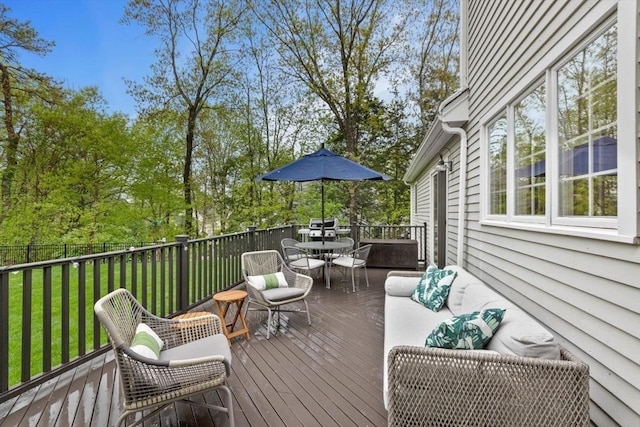 wooden terrace featuring outdoor dining area and a yard