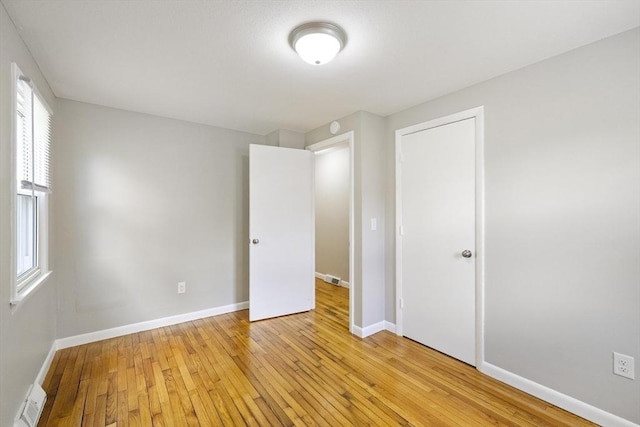 unfurnished bedroom with light wood-type flooring and baseboards