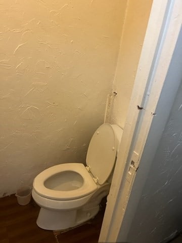 bathroom with toilet and hardwood / wood-style flooring