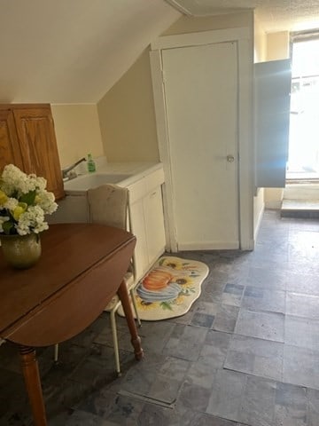 bathroom with sink, lofted ceiling, and tile patterned flooring