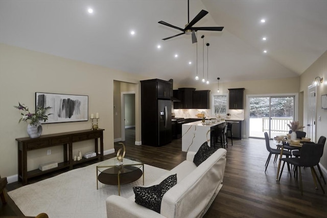 living room with ceiling fan, high vaulted ceiling, and dark hardwood / wood-style flooring