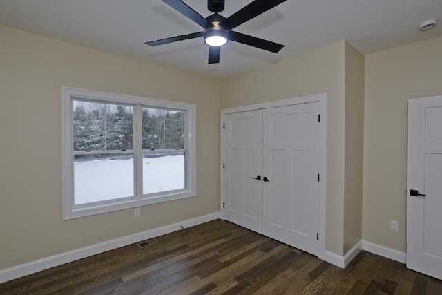 unfurnished bedroom featuring a closet, ceiling fan, and dark hardwood / wood-style flooring