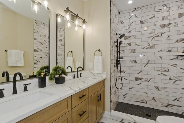 bathroom with tiled shower and vanity