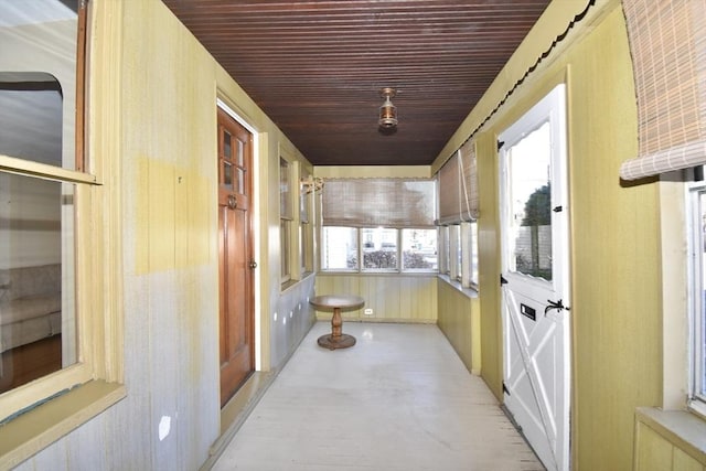 hall featuring wood walls and wood ceiling