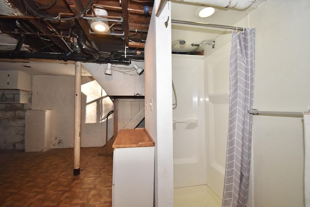 bathroom featuring walk in shower and parquet flooring