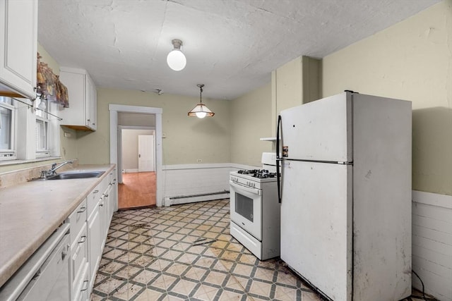 19-21 Pleasant St, North Andover, MA 01845 - kitchen with white appliances, a sink, a baseboard radiator, white cabinets, and a wainscoted wall