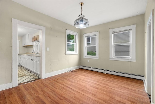 19-21 Pleasant St, North Andover, MA 01845 - unfurnished dining area with a baseboard radiator, light wood-style flooring, baseboards, and a sink