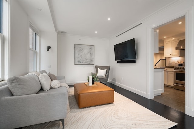 living room featuring dark wood-type flooring and crown molding