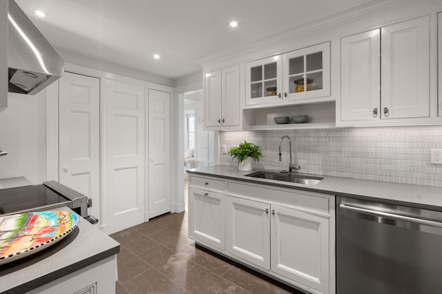 kitchen with dark tile floors, dishwasher, white cabinetry, wall chimney exhaust hood, and sink