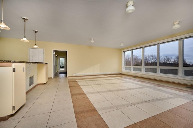 spare room featuring light tile patterned floors and baseboards