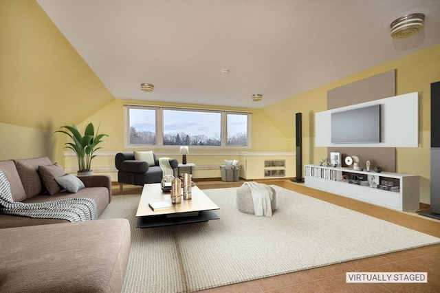 living area featuring tile patterned floors and lofted ceiling