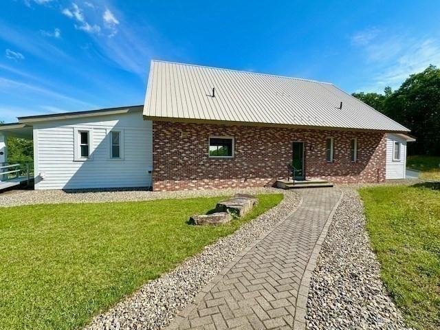 back of property with a yard and brick siding