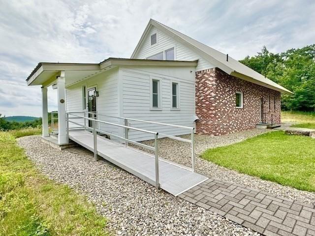 view of side of property with a lawn and brick siding