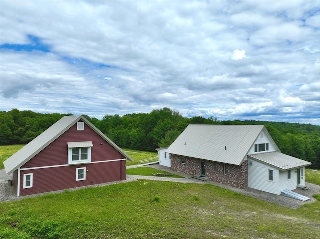 view of home's exterior featuring a view of trees and a yard