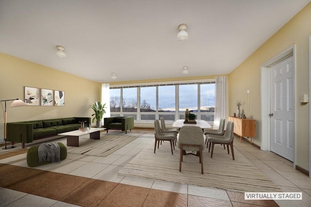 dining space featuring light tile patterned floors and floor to ceiling windows