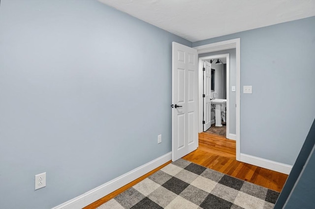 unfurnished bedroom with wood finished floors and baseboards
