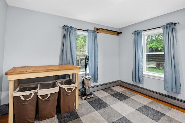 office with plenty of natural light, wood finished floors, and a baseboard radiator