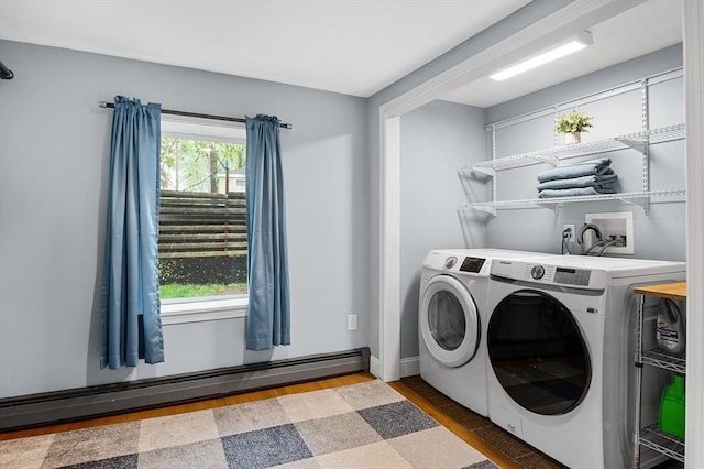laundry room with separate washer and dryer, baseboard heating, and baseboards