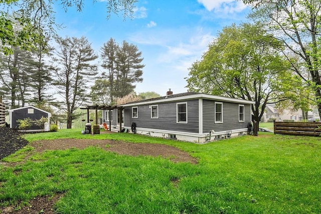 back of house with a lawn and a chimney