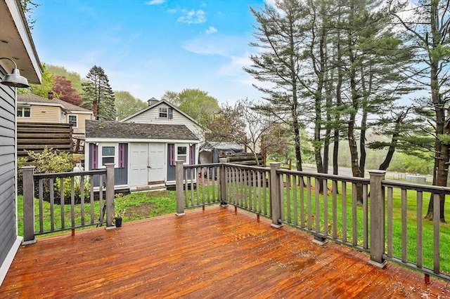 wooden terrace featuring an outdoor structure and a yard
