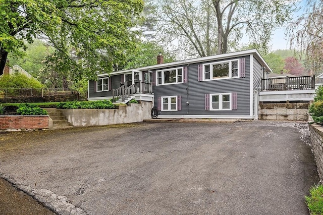 view of front of house featuring a chimney and a deck