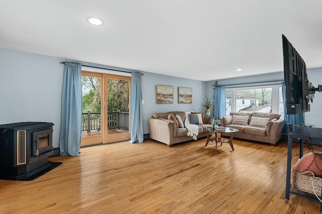 living area with a wood stove, light wood-type flooring, and recessed lighting