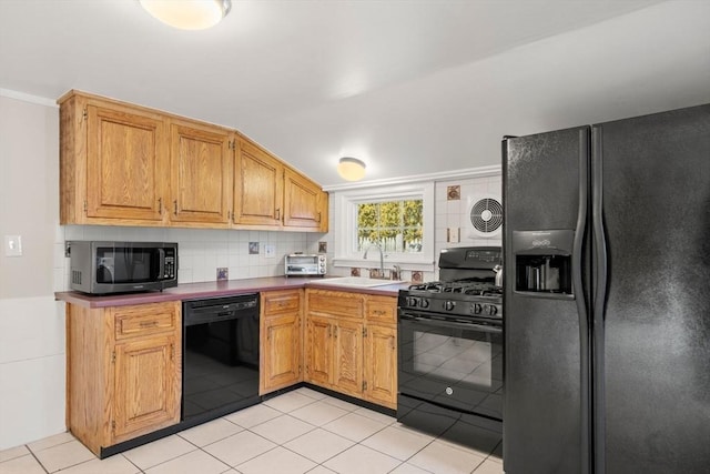 kitchen featuring sink, tasteful backsplash, vaulted ceiling, light tile patterned floors, and black appliances