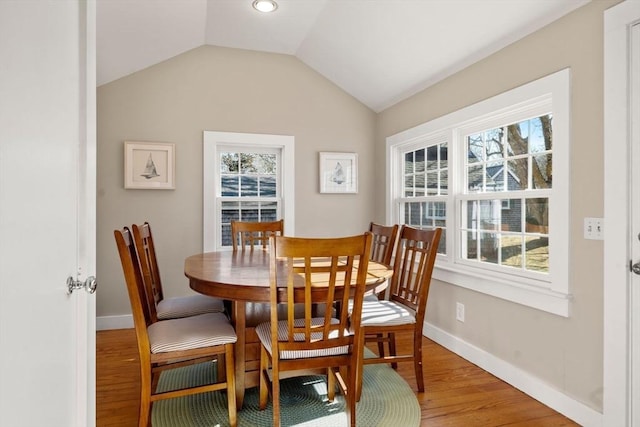 dining room with lofted ceiling and hardwood / wood-style floors