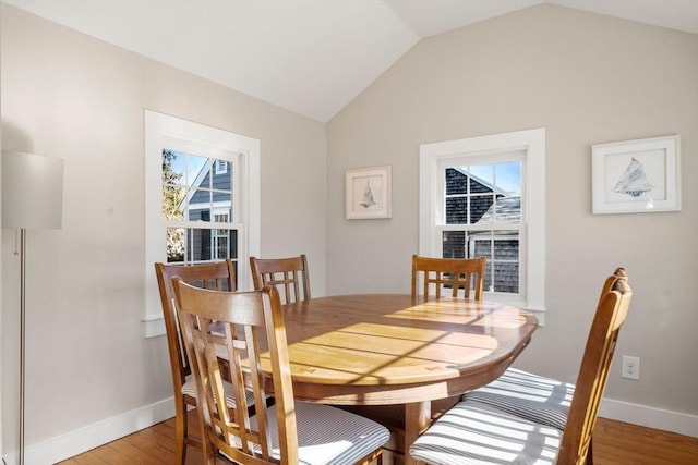 dining space with lofted ceiling and light hardwood / wood-style floors