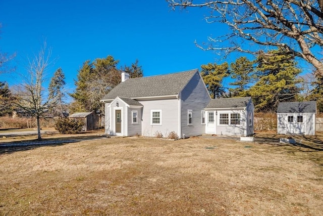 back of property with a lawn and a shed