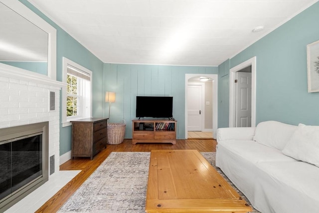 living room with a fireplace and light wood-type flooring