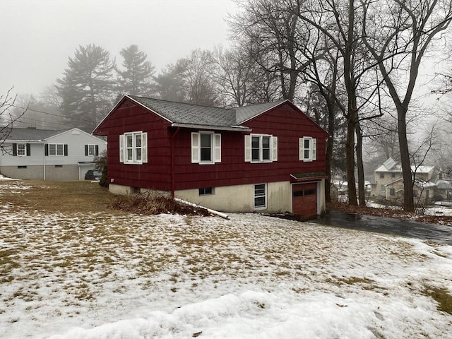 view of snowy exterior featuring a garage